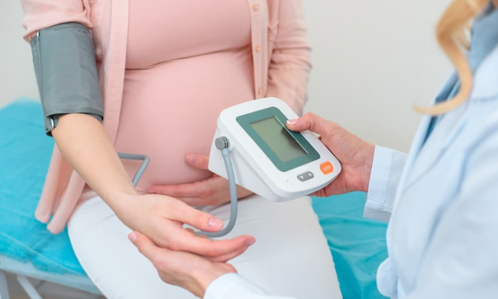 A pregnant woman having her blood pressure professionally monitored.