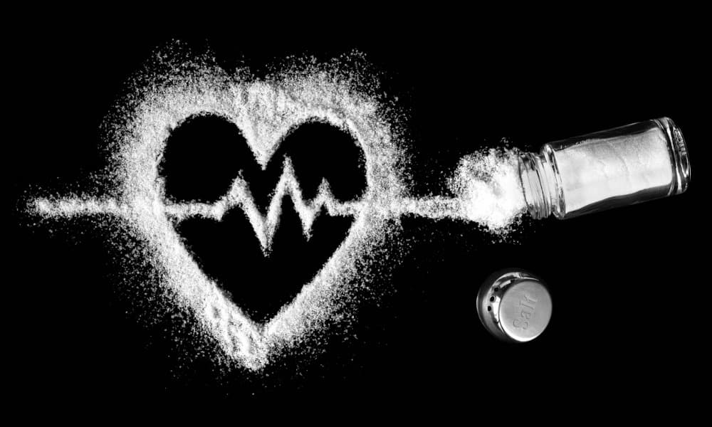 A heart shape and cardiogram being poured from a saltshaker